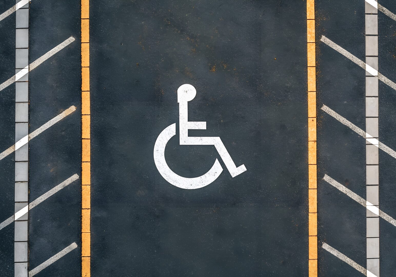 Aerial View of Handicapped Parking Spot on Asphalt with Striped Markings and Yellow Lines
