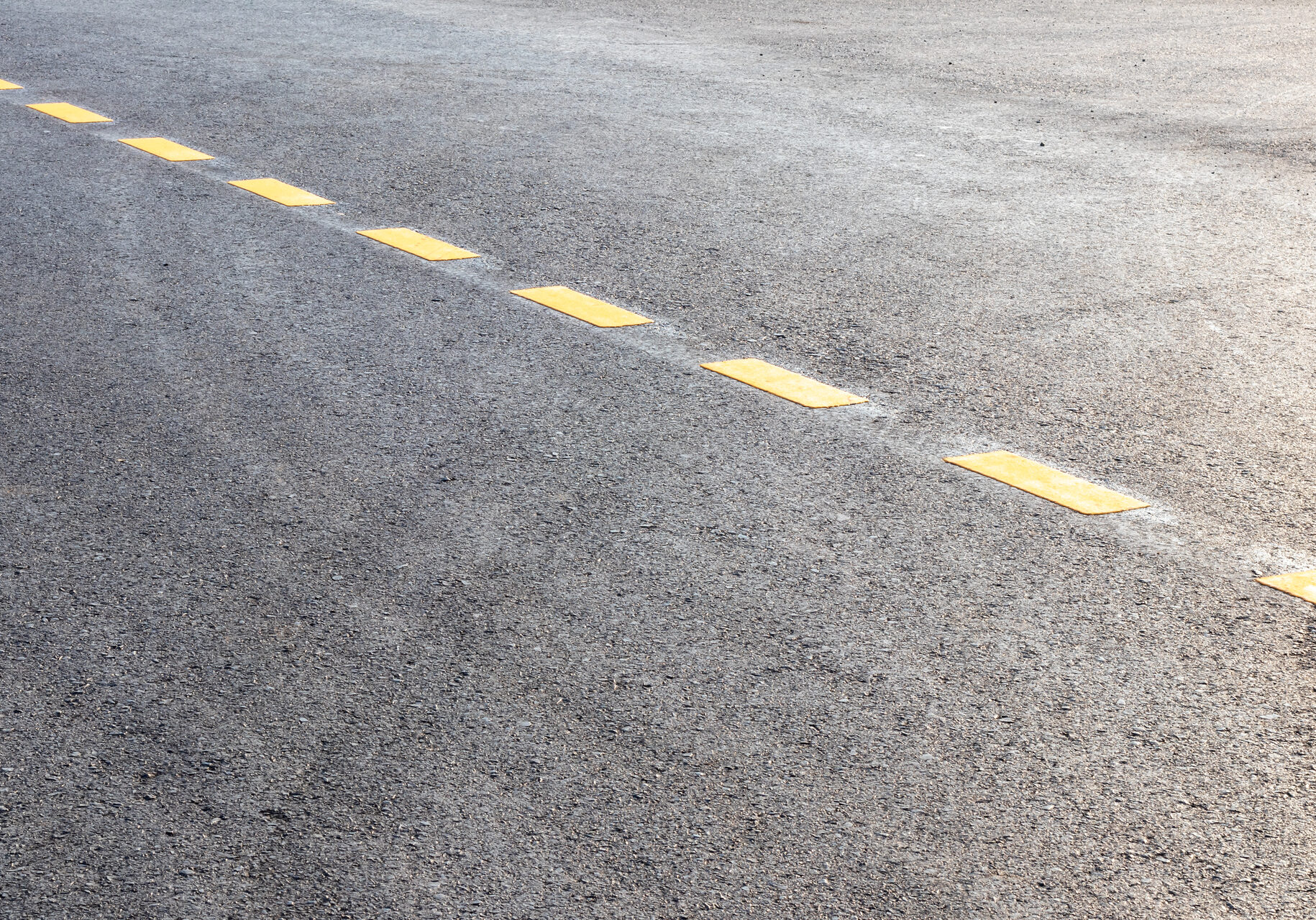 The background of the surface of the road is backlit in the afternoon with a yellow dotted line in one of the rural areas of Thailand.